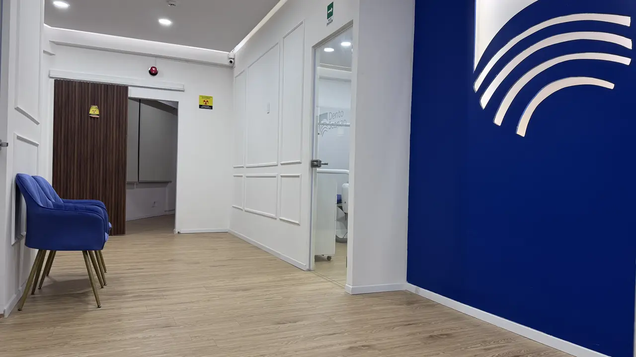 Sala de espera con sillones azules y muro azul con el símbolo de la marca
